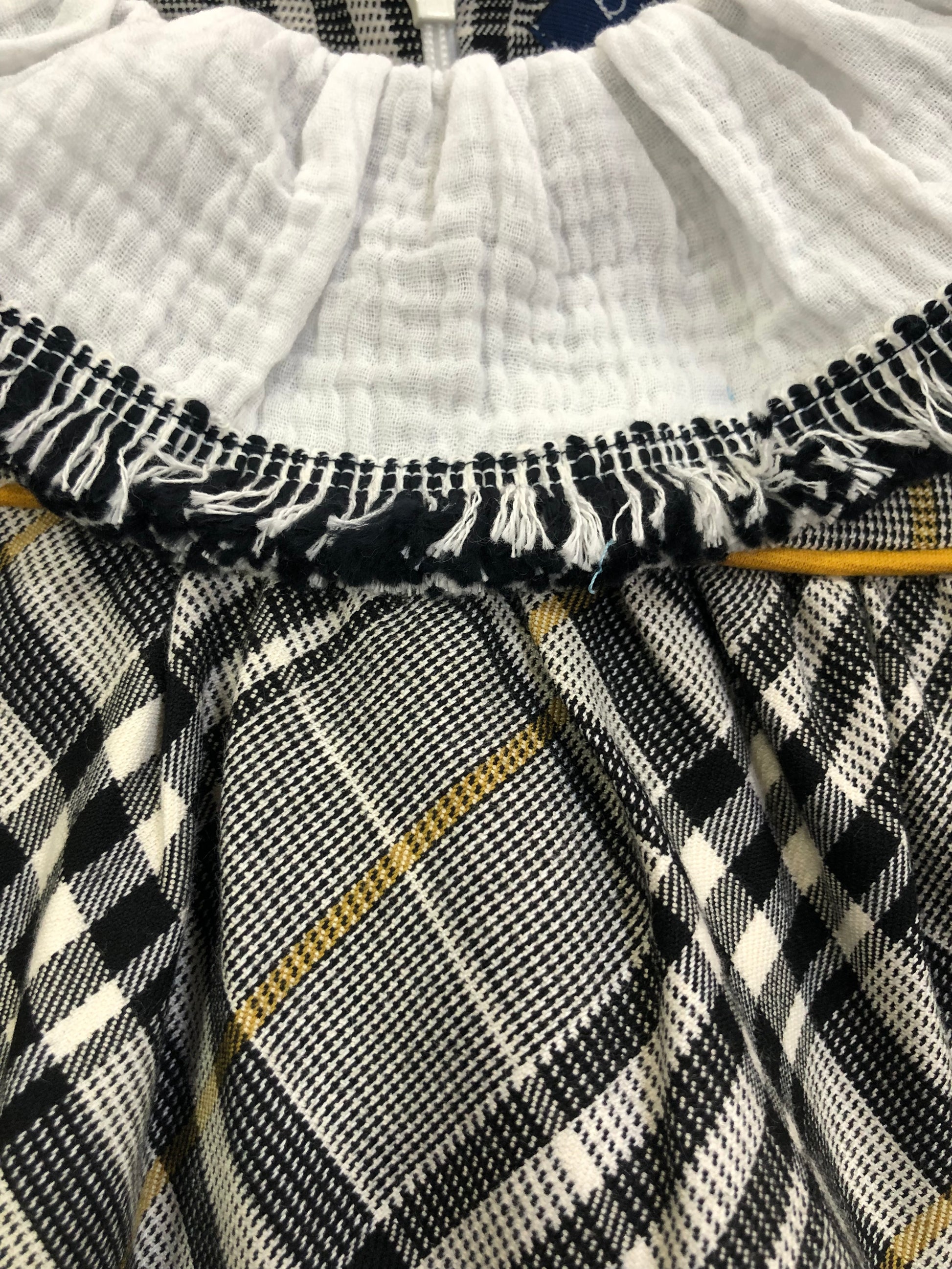 Vestido de niña de cuadros blancos, negros y mostaza - Basmarti de invierno 2024 - Detalle 1 - Moda Infantil Chicle